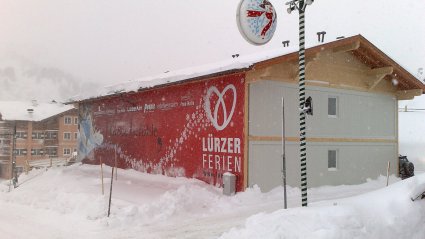 Zweistöckige Wohncontaineranlage für Personal, Geschoß- und Etagenverkleidung aus Holz, Satteldach und großflächige Werbeanbringung