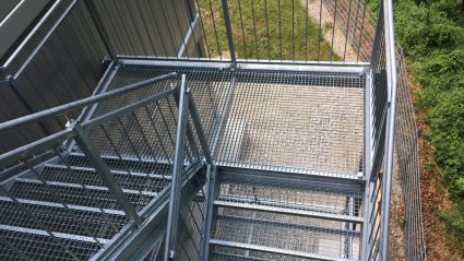 Fluchttreppe mit Gitterrostelementen und Edelstahlgeländer für ein dreistöckiges Containerbüro