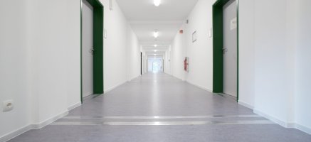 Beleuchteter Flur mit Vinylboden und bodengleiche Kopplungen in einem Schulcontainergebäude