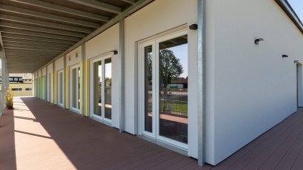 &Uuml;berdachte Balkonanlage im Obergescho&szlig; eines zweist&ouml;ckigen Kindergarten-Modulbaus