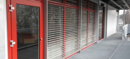 Mehrstöckiges Modulgebäude mit vollflächigen Tür- und Fensterelementen mit Raffstore