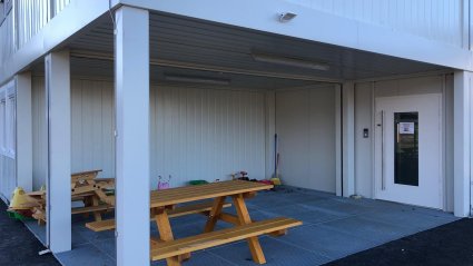 Außenansicht überdachter Eingangsbereich einer zweigeschossigen Kindergarten-Container-Anlage