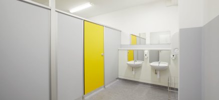 Helle Sanitärräume in Schulcontaineranlage mit Waschbecken, Spiegel und Trennwände