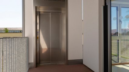 Außenliegende Liftanlage im Obergeschoß eines zweistöckigen Kindergarten-Modulbaus mit barrierefreiem Zugang und Balkongeländer