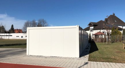 Seitliche Au&szlig;enansicht einer modularen Containeranlage aus wei&szlig;en 20-Fu&szlig; und 16-Fu&szlig; Containern
