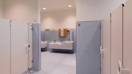 Gro&szlig;z&uuml;gige Sanit&auml;ranlage in einem Kindergarten-Modulbau mit kindgerechter Ausstattung, Doppelwaschbecken, wei&szlig;en Toilettentrennw&auml;nden und hellblaue Boden- und Wandfliesen
